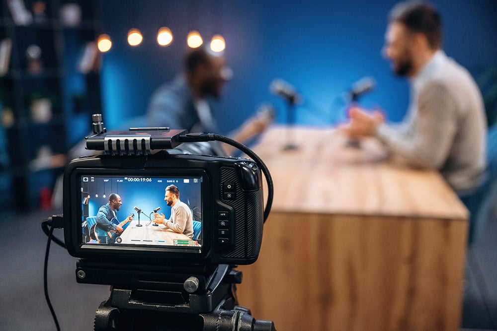 Two men at a table recording a podcast